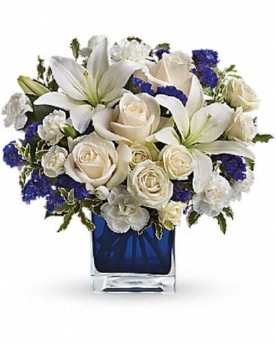 <div class="m-pdp-tabs-description">
<div id="mark-1" class="m-pdp-tabs-marketing-description">Send someone a bit of heaven with this beautiful bouquet. Luxurious crème roses and pure white lilies paint a peaceful picture inside a blue cube.</div>
</div>
Crème roses, white asiatic lilies and white miniature carnations are mixed with bursts of purple statice and green pitta negra. Delivered in a glass cube.
<ul>
 	<li>Our florists hand-design each arrangement, so colors, varieties and container may vary due to local availability</li>
</ul>