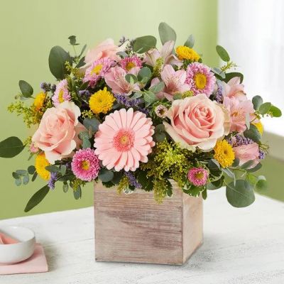 Spring is a time to refresh and reach out. Our spring bouquet celebrates that sentiment. Soft pink and yellow blooms are loosely gathered with lush greenery for style and texture. Designed in our rustic, grey-washed wooden cube, it’s a gift that delivers on your feelings in the most beautiful way.
<ul>
 	<li>Our florists hand-design each arrangement, so colors, varieties and containers may vary due to local availability</li>
</ul>