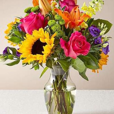 The Best Day™ Bouquet is ready to create a moment your recipient will always remember! An instant mood booster with it's mix of bright bold colors, this gorgeous fresh flower arrangement brings together sunflowers, hot pink roses, purple double lisianthus, orange LA Hybrid Lilies, yellow snapdragons, green button poms, and lush greens to make this day, their best day. Presented in a clear glass vase, this fresh flower arrangement is made just for you to help you send your warmest birthday, congratulations, or get well wishes to your favorite friends and family.
<ul>
 	<li>Our florists hand-design each arrangement, so colors, varieties and containers may vary due to local availability</li>
</ul>