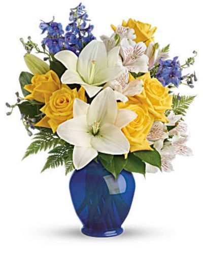 Like a sunny day at the shore, this bright bouquet invigorates and inspires! Radiant yellow roses, white lilies and blue delphinium are expertly arranged.
Sunny yellow roses, white asiatic lilies, white alstroemeria, and blue delphinium are arranged with leatherleaf fern and lemon leaf.
<ul>
 	<li>Our florists hand-design each arrangement, so colors, varieties and containers may vary due to local availability</li>
</ul>