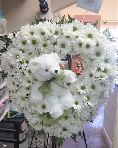 Send love and hugs with this sweet wreath featuring a keepsake plush. From welcoming a new baby to care and concern, this thoughtful arrangement will speak volumes when words may fail.
<ul>
 	<li>Our florists hand-design each arrangement, so colors, varieties and containers may vary due to local availability</li>
</ul>