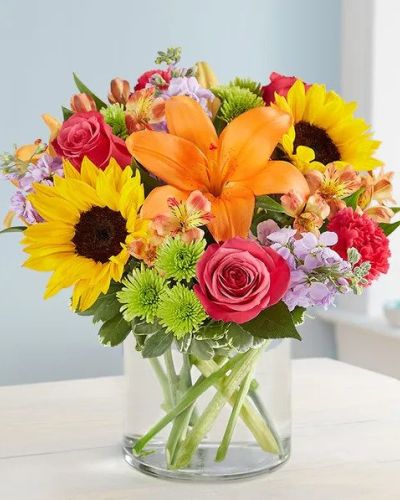 Like a warm embrace, our vibrant flower bouquet delivers your sentiments to someone special. A rich gathering of yellow and orange blooms, with pops of bright pink and purple, it's more than a gift - it's a way to express how you feel inside.