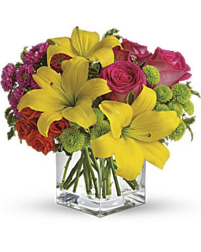 Splash into spring! Sun-bright yellow, hot pink and orange blooms add up to a sensational and oh-so-stylish spring & summer floral arrangement for any occasion.
Hot pink and orange roses are mixed with yellow asiatic lilies, hot pink matsumoto asters and lime green button spray chrysanthemums in a clear glass cube vase.
<ul>
<li>Our florists hand-design each arrangement, so colors, varieties and containers may vary due to local availability</li>
</ul>
