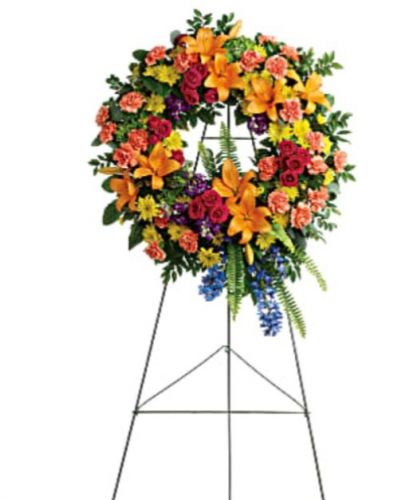 <div id="mark-1" class="m-pdp-tabs-marketing-description">Like a beacon of love and hope, this glorious wreath of hydrangea, roses and lilies echoes the joy of your precious memories.</div>
<div id="desc-1">
<ul>
 	<li>This wreath features green hydrangea, hot pink spray roses, orange asiatic lilies, orange carnations, blue delphinium, purple stock, yellow cushion spray chrysanthemums, huckleberry, variegated pittosporum, sword fern, silver dollar eucalyptus, and lemon leaf.</li>
 	<li>Delivered on a wire easel.</li>
 	<li>Our florists hand-design each arrangement, so colors, varieties and containers may vary due to local availability</li>
</ul>
</div>