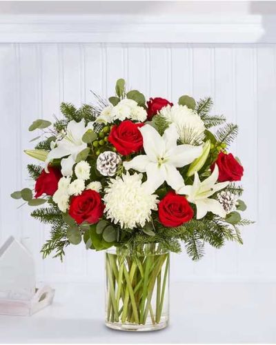 We’ve taken one of our best-selling bouquet designs and filled it with all the joyful colors and textures of the holiday season. An abundant, garden-inspired mix of blooms is gathered with glittery natural accents inside a clear glass vase. It’s a gift guaranteed to make a grand impression at every gathering.
<ul>
 	<li>All-around arrangement with red roses, white Oriental lilies, football mums and button poms, green hypericum; accented with silver dollar eucalyptus, assorted Christmas greens and glittered pinecones</li>
 	<li>Artistically designed in a clear glass vase</li>
 	<li>Extra large arrangement measures approximately 33"H x 20"W</li>
 	<li>Large arrangement measures approximately 31"H x 19"W</li>
 	<li>Medium arrangement measures approximately 28"H x 19"W</li>
 	<li>Small arrangement measures approximately 27H x 18"W</li>
 	<li>Our florists hand-design each arrangement, so colors, varieties and container may vary due to local availability</li>
 	<li>To ensure lasting beauty, Oriental lilies may arrive in bud form and will fully bloom over the next few days</li>
 	<li>Our florists hand-design each arrangement, so colors, varieties and containers may vary due to local availability</li>
</ul>