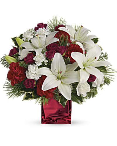 Filled with holiday charm. Red spray roses and white asiatic lilies are arranged to perfection in a cube.
<ul>
 	<li>Our florists hand-design each arrangement, so colors, varieties and containers may vary due to local availability</li>
</ul>