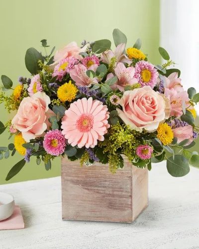 Spring is a time to refresh and reach out. Our spring bouquet celebrates that sentiment. Soft pink and yellow blooms are loosely gathered with lush greenery for style and texture. Designed in our rustic, grey-washed wooden cube, it’s a gift that delivers on your feelings in the most beautiful way.
<ul>
 	<li>Our florists hand-design each arrangement, so colors, varieties and containers may vary due to local availability</li>
</ul>