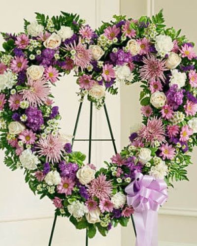 The passing of a beloved family member or friend is a sad and difficult time. You want to convey your deepest sympathies to those left behind while also remembering and celebrating a beautiful life. This striking, heart-shaped tribute is crafted by our expert florists from delicate lavender and white blooms and is a beautiful expression of all the love you feel in your heart. Traditionally sent directly to the funeral home by family members or friends and displayed on a stand.
<ul>
 	<li>Our florists hand-design each arrangement, so colors, varieties and containers may vary due to local availability</li>
</ul>
