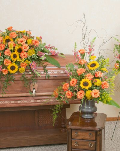 Includes a casket spray, standing spray and urn design in the warm colors of a sunset.
<ul>
 	<li>Our florists hand-design each arrangement, so colors, varieties and containers may vary due to local availability</li>
</ul>