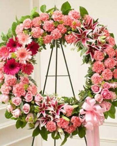 This pink standing wreath perfectly expresses your love and concern at this difficult time. Softly colored flowers such as roses, stargazer lilies, carnations and more are accented by salal and seeded eucalyptus. Traditionally sent directly to the funeral home by family, friends and business associates.
<ul>
 	<li>Our florists hand-design each arrangement, so colors, varieties and containers may vary due to local availability</li>
</ul>
