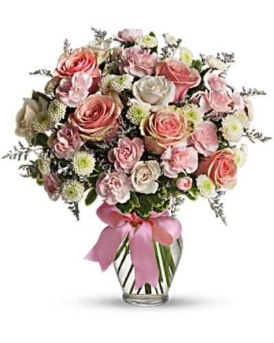 Pretty pink roses, spray roses and miniature carnations, white button spray chrysanthemums, lavender limonium and green pittosporum fill a spring glass vase that's wrapped with a pink satin ribbon. It's confection perfection!
<ul>
 	<li>Our florists hand-design each arrangement, so colors, varieties and container may vary due to local availability</li>
</ul>