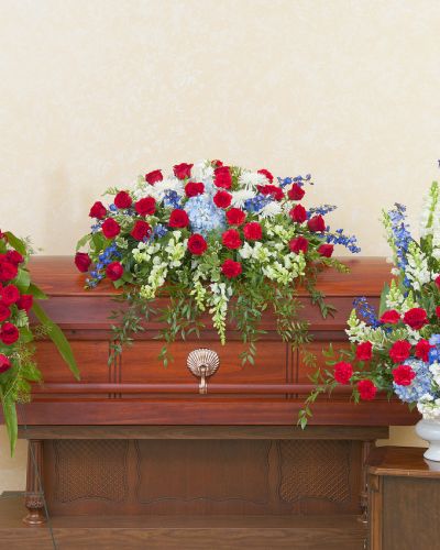 A patriotic casket spray, standing spray, and urn in red, white and blue.
<ul>
 	<li>Our florists hand-design each arrangement, so colors, varieties and containers may vary due to local availability</li>
</ul>