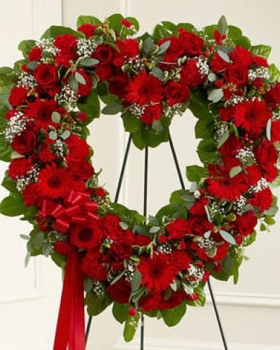 The passing of a loved one deserves a special tribute. This open heart standing display of fresh red blooms is designed by our expert florists to help you express all the devotion and sympathy you want to convey at a sad and difficult time. Featuring fresh red roses, gerbera daisies and carnations, this arrangement is accented by baby's breath, salal, seeded eucalyptus and more. Traditionally sent directly to the funeral home by family members or friends and displayed on a stand.
<ul>
 	<li>Our florists hand-design each arrangement, so colors, varieties and containers may vary due to local availability</li>
</ul>