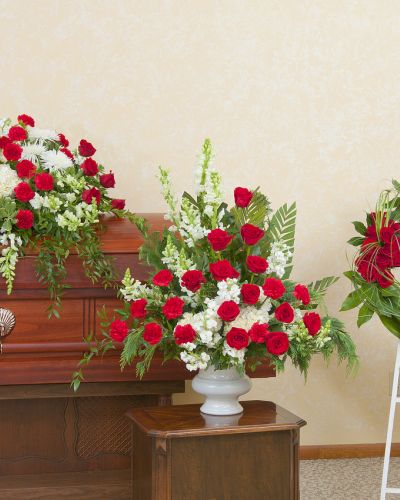 Red and white casket spray, urn and wreath.
<ul>
 	<li>Our florists hand-design each arrangement, so colors, varieties and containers may vary due to local availability</li>
</ul>
