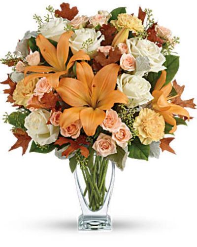 Capture the natural beauty of autumn with this stunning arrangement of lilies and roses in an elegant glass vase, sure to brighten any fall day.
This beautiful arrangement features white and peach roses, peach asiatic lilies and peach carnations and is finished with dusty miller, seeded eucalyptus, brown oak leaves and lemon leaf.