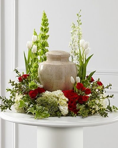 The FTD® Tears of Comfort™ Arrangement is an elegant and sophisticated way to surround their urn with floral beauty at the final farewell service. Rich red roses and spray roses are vivid and bright arranged amongst white tulips, larkspur, hydrangea, and trachelium, accented with the bright greens of Bells of Ireland, hypericum berries, ivy and myrtle, creating a wonderful way to honor the life of the deceased.
<ul>
 	<li>Our florists hand-design each arrangement, so colors, varieties and containers may vary due to local availability</li>
</ul>